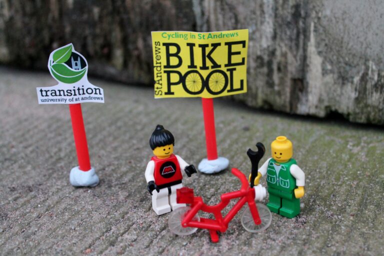 play figures standing near a poster of the transition Bike Pool project